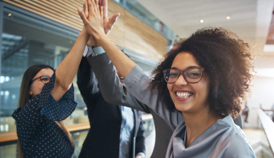 Picture of teammates smiling and high-fiving, implying they’ve reached their improvement goals