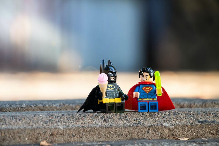 An image of lego batman and robin on the sidewalk