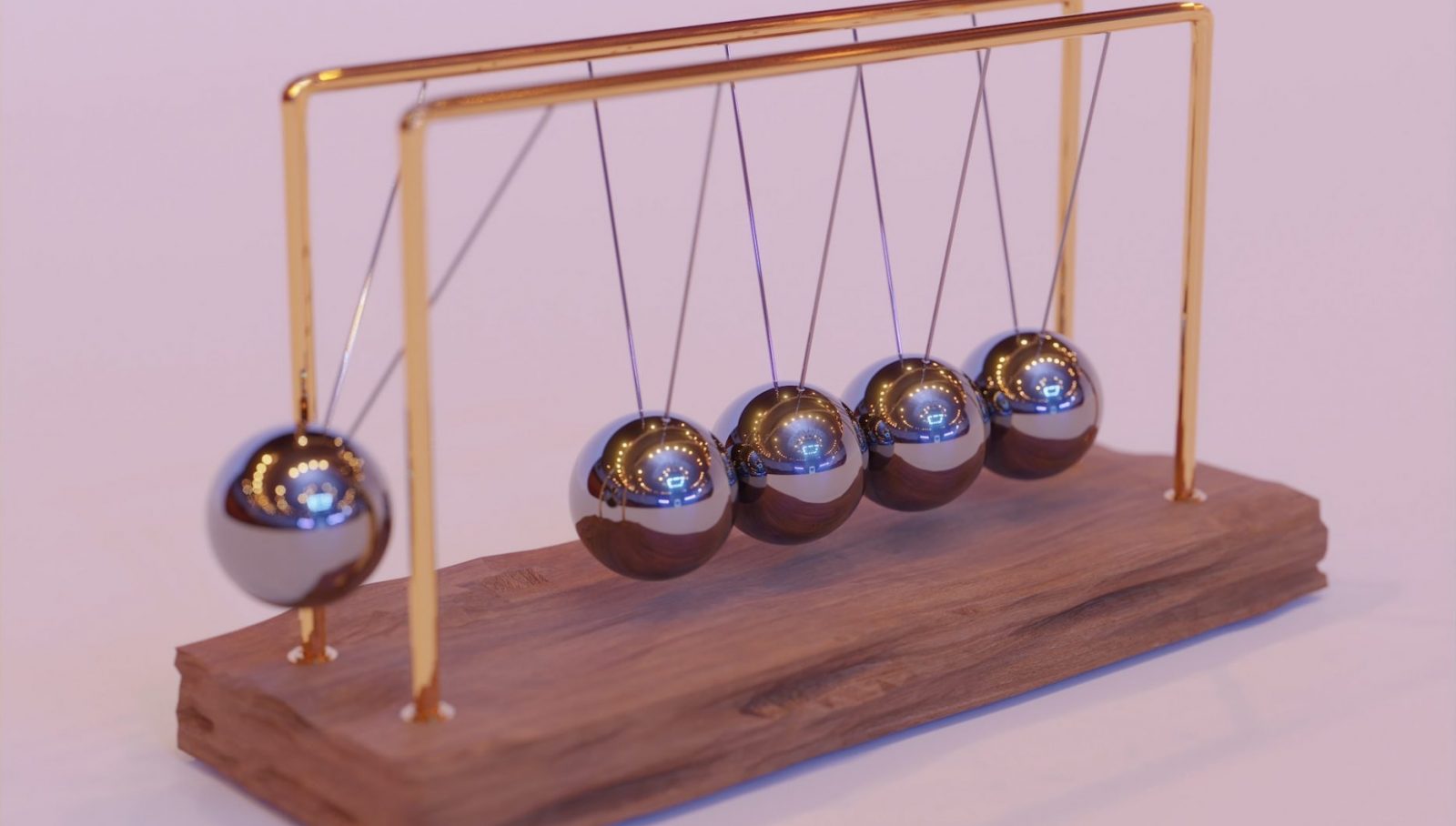 Wooden stand with metal balls hitting the others