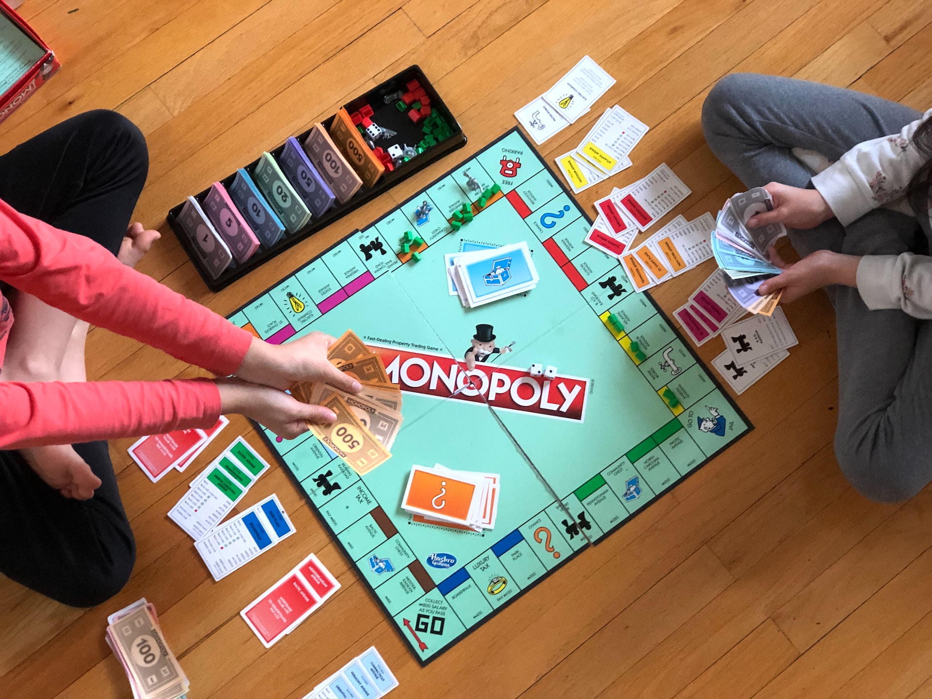 Two people sitting in front of a Monopoly board