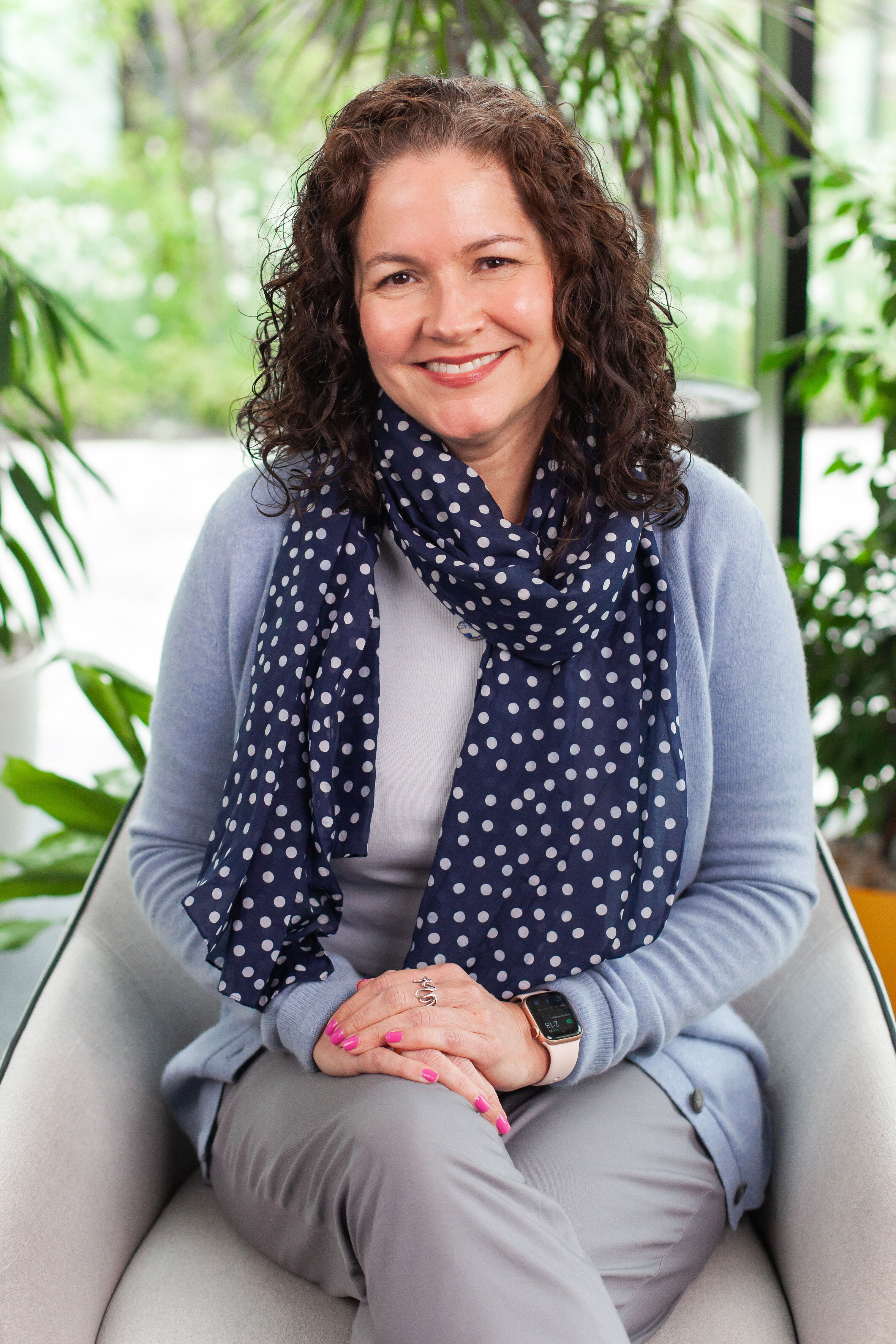 christine royston sitting on a chair in an office, with plants in background